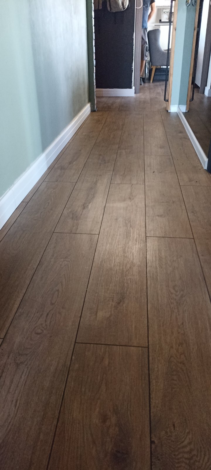 Δάπεδο laminate σε απόχρωση δρυς, τοποθετημένο σε διάδρομο κατοικίας με λευκά σοβατεπί